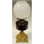 A late Victorian/early 20th century oil lamp with cranberry glass reservoir, gilt metal base c.