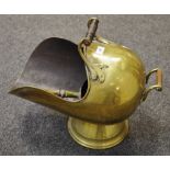 A late Victorian helmet shaped brass coal scuttle and shovel; an oak framed woolwork firescreen;