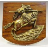 A brass wall plaque of a mounted knight