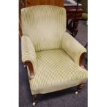 A Victorian library chair, padded back, scrolling arms, stuffed overseat, turned fore legs,