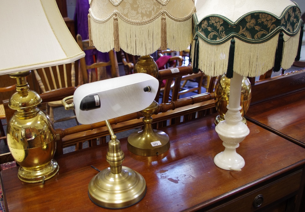 A pair of brass table lamps; another; a marble table lamp; a desk light.