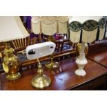 A pair of brass table lamps; another; a marble table lamp; a desk light.