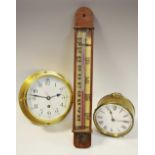 A brass porthole clock, enamel dial with stylised numericals,