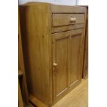 An early 20th century pine utility cupboard, shaped gallery, single drawer over panel door cupboard,