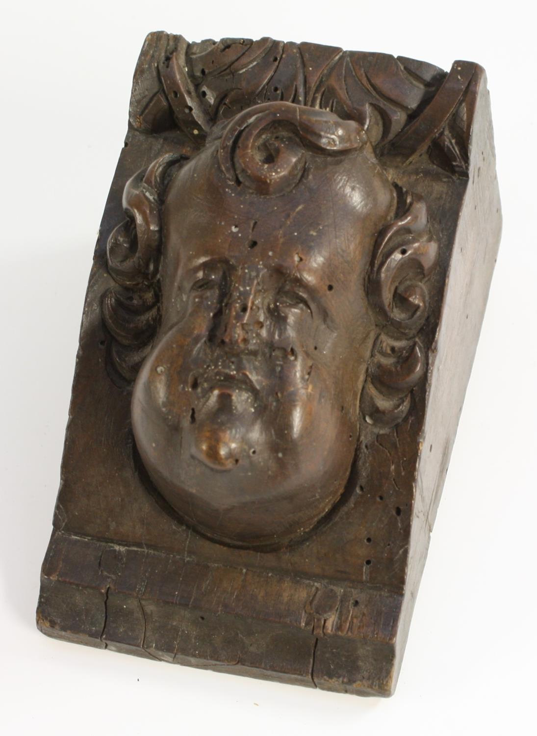 A 17th century walnut sculptural architectural fragment, carved with a putto mask, 12cm x 7.5cm, c.