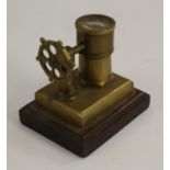 An early 20th century novelty desk lighter, as a ship’s wheel and compass, rectangular base, 8.