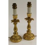 A pair of early 20th century gilt metal table lamps, the candlesticks cast and chased with acanthus,