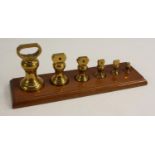 A graduated set of six brass pharmaceutical bell weights, 1lb to 1/2oz,