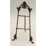 A 19th century gilt metal table-top easel, in the Baroque taste, crested by a foliate mask,