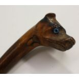 A 19th century novelty riding crop or child's walking cane, the pommel carved as the head of a dog,