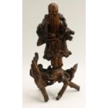 A Chinese rootwood figure, carved as a bearded immortal holding a peach, 45cm high,