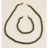 A 9ct gold mounted Chinese jade bead necklace, 44.5cm long; a bracelet, similar, 18.
