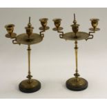 A pair of Aesthetic Movement brass three-light candelabra, the central campana sconce with snuffer,