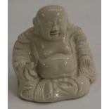 A Chinese Dehua blanc de chine porcelain figure, of the rotund Budai seated, holding a lotus, 10.