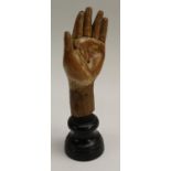 A softwood statuary fragment, carved as a hand, mounted for display, 23.