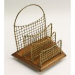 An Edwardian brass and oak letter rack, faux-woven divisions, trapezoid base, brass ball feet, 19.