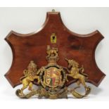 A cast Royal coat of Arms armorial on mahogany plaque