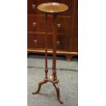An Edwardian mahogany jardiniere stand, trio of columns above shaped undertier with outswept legs c.