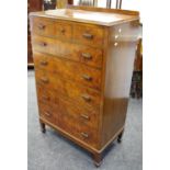 A 1940/50's walnut veneered tall chest of three short drawers over five graduated long.