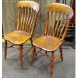 A pair of beech and elm lath back kitchen dining chairs.
