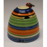 A Clarice Cliff Bee skep preserve pot and cover, banded in colours bee finial, 8cm high,