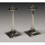 A pair of silver table candlesticks, in the manner of Archibald Knox,