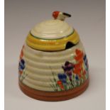 A Clarice Cliff Crocus pattern Bee skep preserve pot and cover, painted in colours with crocuses,