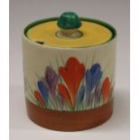 A Clarice Cliff Crocus pattern cylindrical preserve pot and cover, painted in colours with crocuses,