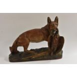 A French painted terracotta model of a startled fox caught with a game bird in his jaws,