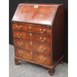 A George III style bureau, of small proportions, fall front enclosing small drawers and pigeonholes,
