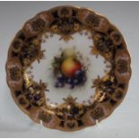 An early 20th century Royal Worcester shaped circular cabinet plate, the central painted with fruit,