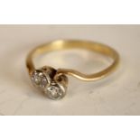 A diamond crossover twist ring, inset with two old brilliant cut diamonds, each approx 0.
