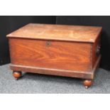 A 19th century oak blanket chest, carry handles to sides, skirted base, bun feet, casters,