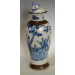 A Chinese baluster vase and cover, painted in underglaze blue with ladies of the court in a garden,