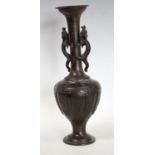 A Chinese bronze slender ovoid vase, the tall flared neck applied with a pair of dragons,