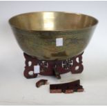 A Chinese brass circular singing bowl, chased with a ferocious dragon and scrolling clouds,