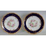 A pair of Royal Crown Derby shaped circular plates, painted by Charles Harris, one signed CH,
