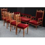 An Arts and Crafts oak drawing room suite, comprising a chaise,