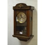 An oak wall clock, silvered dial, Arabic numerals,