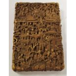 An oriental card case carved with domestic scenes.