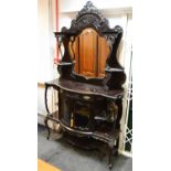 An ebonised mirror back display cabinet, cartouche shaped mirror and plateaus,