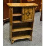 An Arts and Crafts oak bookcase cabinet, bowed top over an arrangement of cupboard and shelving.