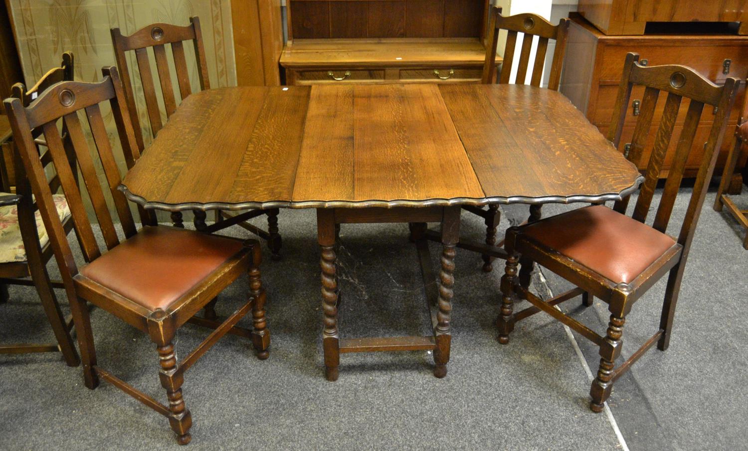 An early 20th century oak pie crust edged 5ft gateleg drop leaf dining table with barley twist
