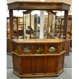 An Old Charm oak bar, carved canted overhang above niche with five coloured glass panels,