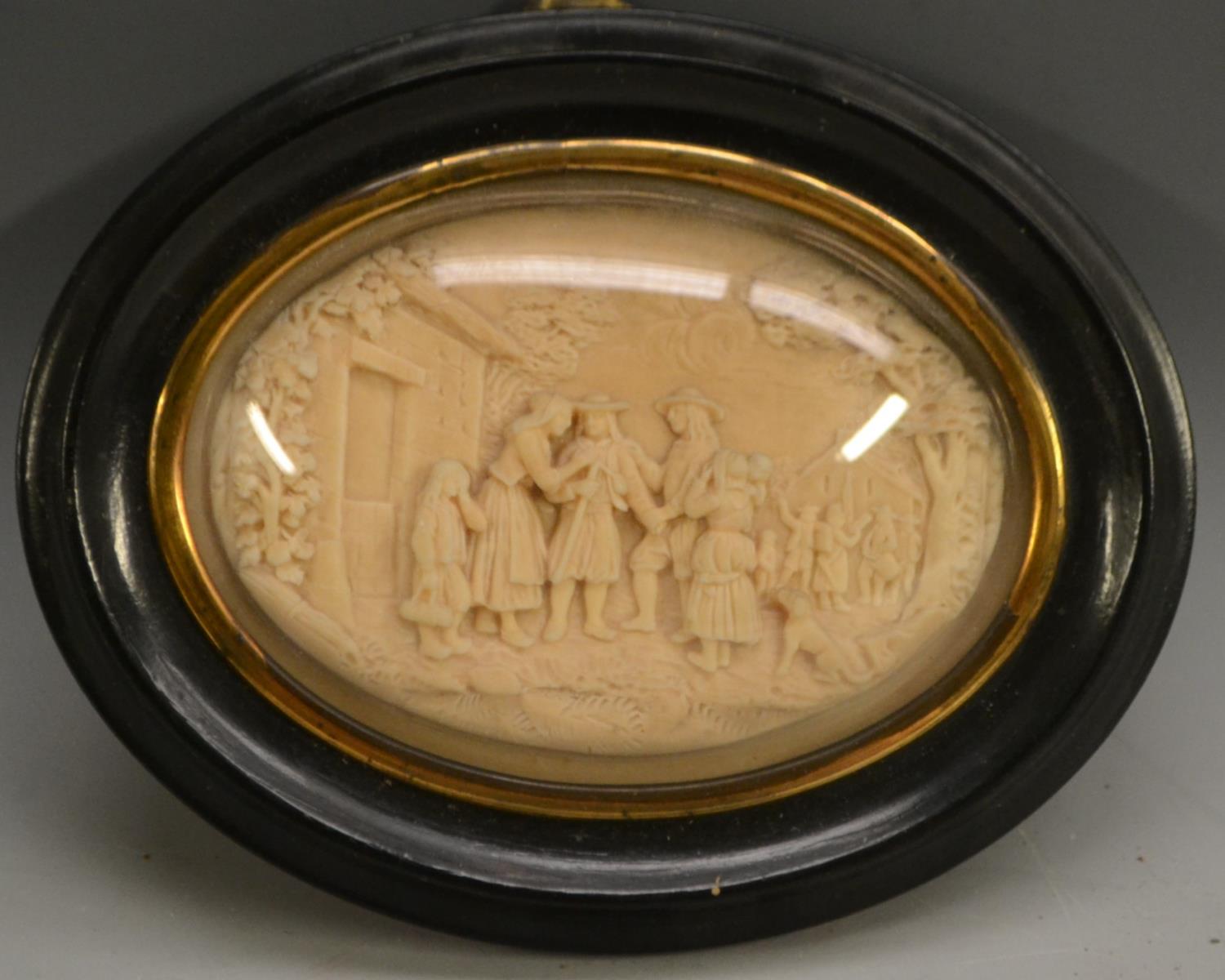 A 19th century wax picture, in relief with a genre scene, oval, 7cm x 9.