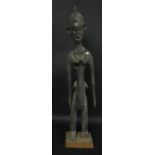 Tribal Art - an African figure, she stands, wearing a bead necklace, a child on her back,