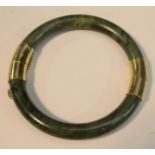 A Chinese gilt metal mounted green hardstone hinged bangle,