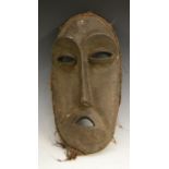 Tribal Art - a Lega mask, of elongated oval outline, with eliptical eyes and demi-lune mouth,