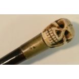 A 'memento mori' walking cane, the pommel as a skull, ebonised shaft, 87.