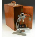 A Beck Binomax jug-handled stereo microscope, two reversible objectives, grey finish, 34cm high,
